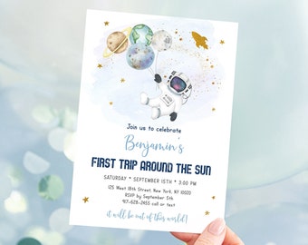 May include: A blue and white invitation card with a watercolor illustration of an astronaut holding balloons shaped like planets. The text on the card reads "Join us to celebrate Benjamin's First Trip Around The Sun. Saturday, September 15th, 3:00 PM. 125 West 18th Street, New York, NY 10020. RSVP by September 5th. 917-628-2455 call or text. It will be out of this world!"