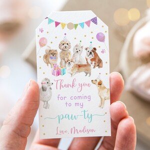 May include: Thank you for coming to my paw-ty. Love, Madison. A white card with a pink, purple, and blue paw-ty theme with a watercolor illustration of dogs wearing party hats.