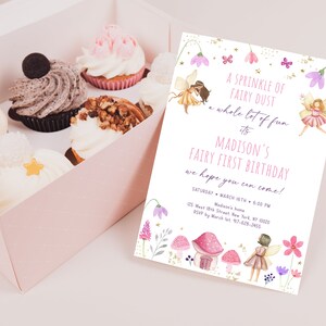 May include: A pink box filled with cupcakes and a matching invitation. The invitation reads "A Sprinkle of Fairy Dust" and announces Madison's Fairy First Birthday. Cupcakes have various toppings.