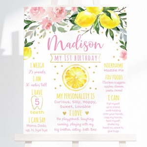 Puede incluir: Un cartel blanco imprimible con temática de limón para un primer cumpleaños. El cartel tiene un diseño floral rosa y detalles de purpurina dorada. Incluye detalles sobre el niño, como su peso, altura, apodo, comidas favoritas y lo que puede hacer. El texto del cartel dice "Madison Mi 1er Cumpleaños".