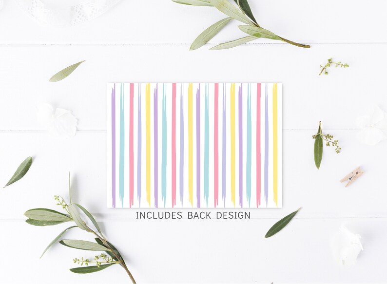 May include: A white card with pastel pink, yellow, blue, and purple stripes. The text "INCLUDES BACK DESIGN" is printed at the bottom of the card.