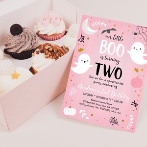 May include: Pink Halloween birthday invitation with a ghost and the text "our little BOO is turning TWO". The invitation has a gold glitter background and features a pumpkin, spider web, and bats.