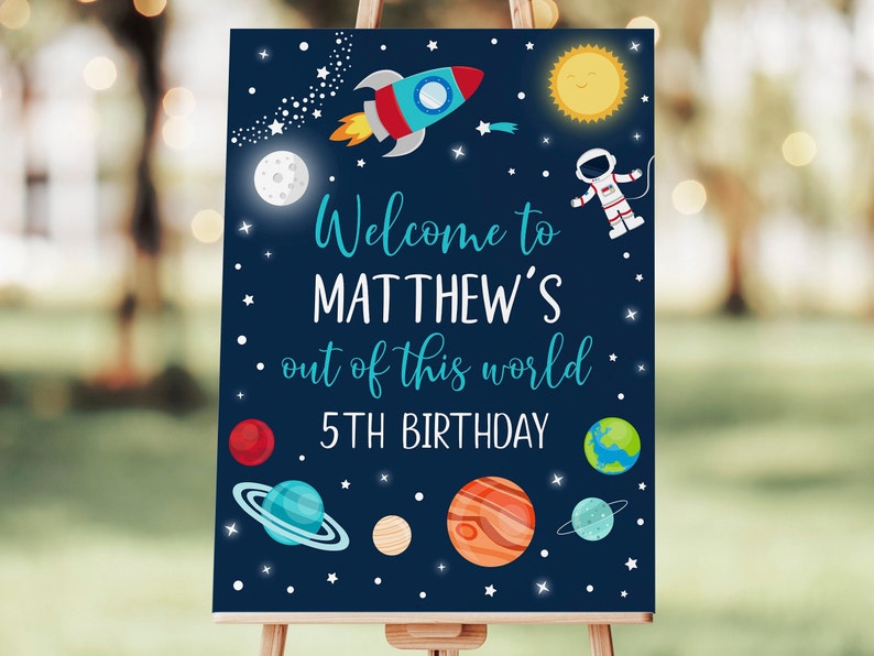 May include: A blue and white welcome sign with a rocket, planets, stars, and an astronaut. The sign says "Welcome to Matthew's Out of this World 5th Birthday".