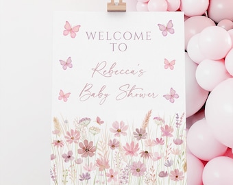 Może przedstawiać: Biały znak na drewnianym sztaludze z napisem "WELCOME TO Rebecca's Baby Shower" w miękkim różowym skrypcie. Znak jest ozdobiony różowymi motylami i kwiatową obwódką z różowych i fioletowych kwiatów. Różowe balony w tle.