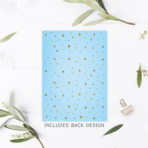 Peut inclure: Une carte bleu clair avec un motif d'&eacute;toiles dor&eacute;es. Le texte "INCLUDES BACK DESIGN" est imprim&eacute; en bas de la carte.