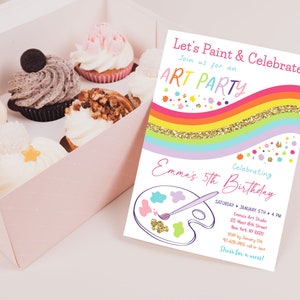 May include: A colorful invitation for an art party celebrating a child's 5th birthday. The invitation features a rainbow with gold glitter, a paint palette, and a paintbrush. The text on the invitation reads "Let's Paint & Celebrate!" and "Emma's 5th Birthday".