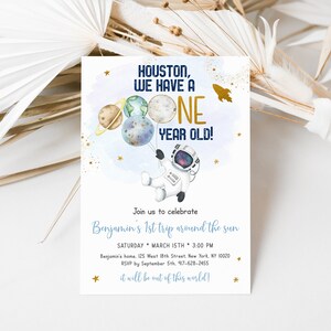 May include: A blue and gold astronaut-themed first birthday party invitation with a cartoon astronaut holding planets and a rocket ship. The text reads "Houston, we have a one year old!" and includes details for the party, including the date, time, and location.
