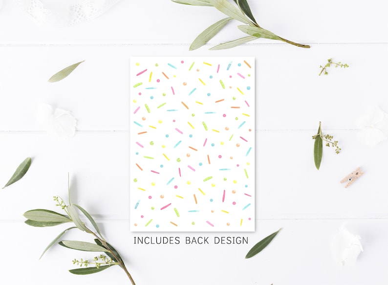 May include: A white card with a colorful confetti pattern. The card says "Includes Back Design" at the bottom.
