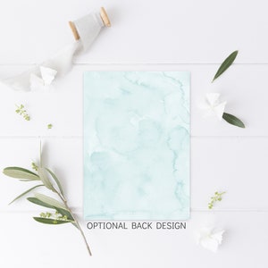 May include: A light blue watercolor background with a white wooden surface and green leaves and white flowers. The text "OPTIONAL BACK DESIGN" is at the bottom of the image.
