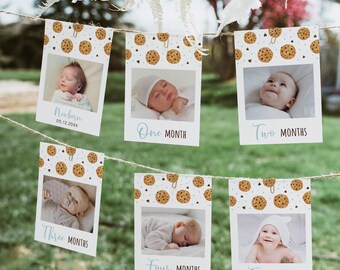 Op de afbeelding: Een set van zes witte fotokaarten met een koekjespatroon. Elke kaart heeft een babyfoto en een maandelijkse mijlpaal, beginnend met "Pasgeboren" en eindigend met "Vijf maanden".