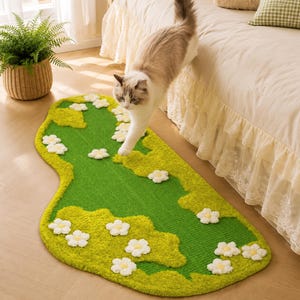 May include: An irregular shaped area rug featuring a vibrant green base with textured lime green patches and scattered white flower appliqués with yellow centers. The rug has a tufted surface texture and is positioned on a light wood floor.