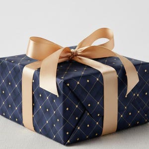 Puede incluir: Un regalo envuelto con papel azul marino con un patrón de diamantes dorados y una cinta de raso dorada a juego atada con un lazo. Listo para una ocasión especial.