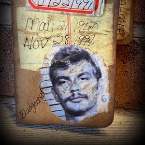 May include: A vintage-style brown paper folder with a photo of a man and the text "CASE# 07221991 May 21 1960 NOV 28 1994" and "BLUDGEONED" written on it.