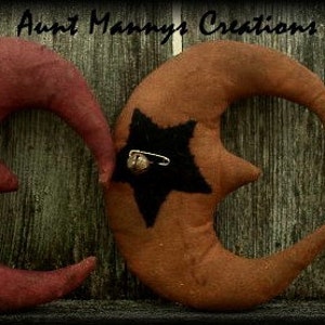 May include: Three handmade felt crescent moons with black felt stars and metal bells. The moons are in shades of red, orange, and brown.