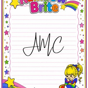 May include: A rectangular stationery sheet featuring the Rainbow Brite logo at the top, pink horizontal lines for writing, and a border decorated with colorful stars and rainbows. The character Rainbow Brite is in the bottom right corner, and the letters AMC are written in black cursive in the center.