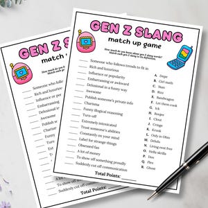 May include: Two white sheets of paper with the text "GEN Z SLANG match up game" printed in black, pink, and blue. The game includes a list of Gen Z slang terms and their definitions. A black pen rests on the bottom right corner.