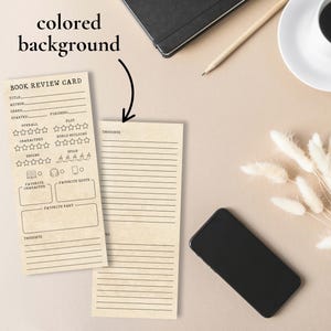 May include: Two beige book review cards with black text, one with rating sections and the other with lined spaces for thoughts. A black smartphone, a cup of coffee, and a pencil are on a beige surface.