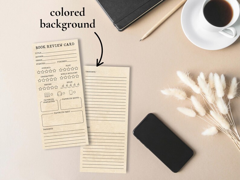 May include: Two beige book review cards with black text, one with rating sections and the other with lined spaces for thoughts. A black smartphone, a cup of coffee, and a pencil are on a beige surface.