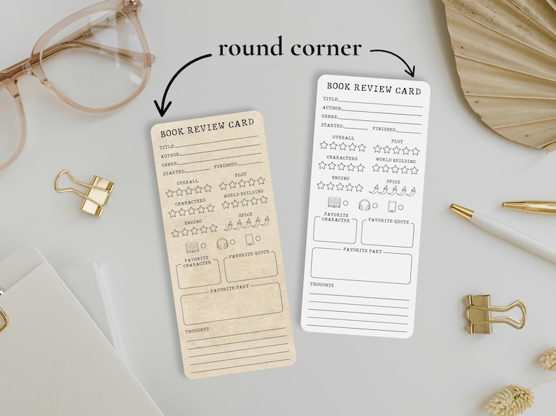 May include: Two rectangular book review cards with rounded corners. One card is tan, the other is white. Both cards have the text "BOOK REVIEW CARD" at the top, with sections for title, author, and plot. There are also sections for rating the book.