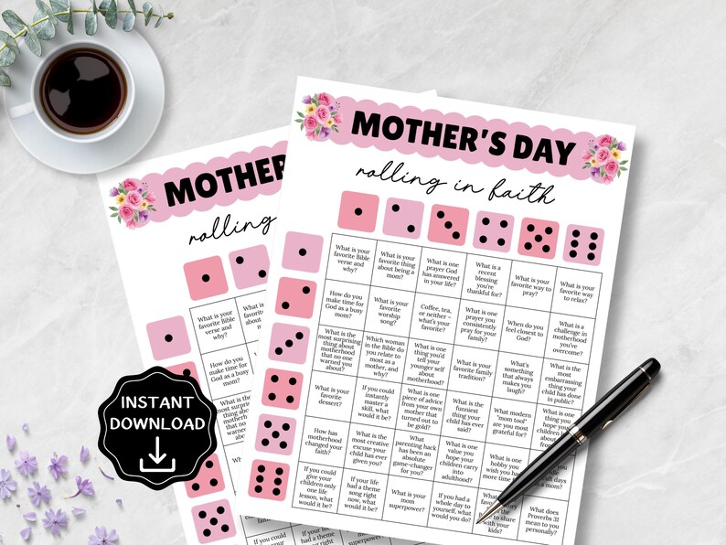 May include: Two printable Mother's Day games with pink dice and floral accents. The text "Mother's Day rolling in faith" is at the top. A black pen and a cup of coffee are also visible. An "Instant Download" graphic is in the lower left.