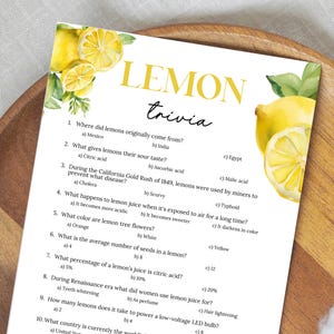 May include: A white sheet with the title "LEMON trivia" in yellow, featuring lemon illustrations. The trivia questions are about lemons, with multiple-choice answers. The sheet is on a wooden tray.