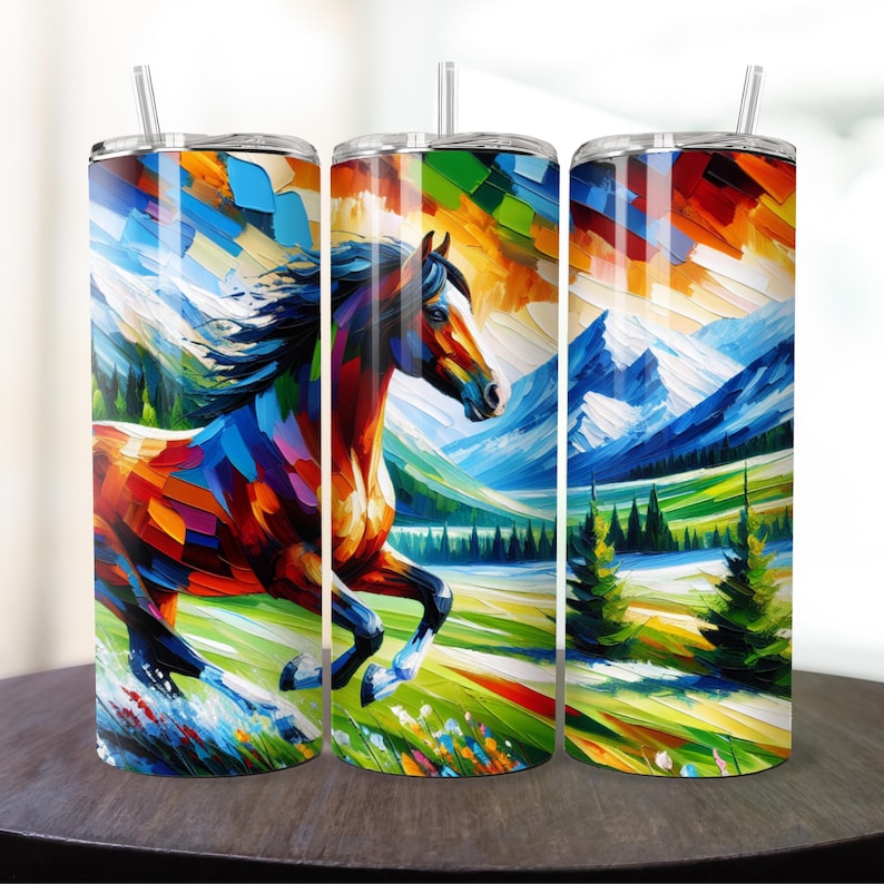 May include: Three stainless steel tumblers with a colorful abstract painting of a horse running through a mountain landscape. The horse is painted in shades of brown, red, blue, green, and yellow. The mountains are painted in shades of blue and white. The background is painted in shades of green and yellow.