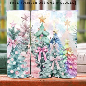 May include: Three watercolour Christmas tree designs on white tumblers. The trees are decorated with pink, blue and rainbow baubles and bows. The background is a soft watercolour wash of pink, blue and yellow.
