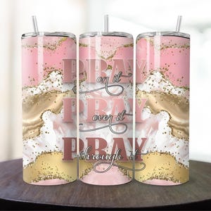 May include: Three pink and gold stainless steel tumblers with the words "Pray on it, Pray over it, Pray through it" in a rose gold font.
