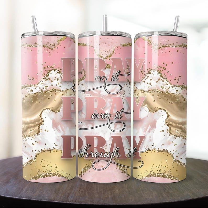 May include: Three pink and gold stainless steel tumblers with the words "Pray on it, Pray over it, Pray through it" in a rose gold font.