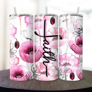 May include: Three stainless steel tumblers with a white background and pink watercolor poppy flower design. The middle tumbler has the word "Faith" written in black cursive.