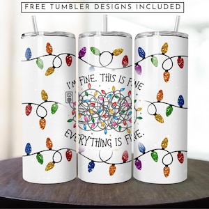 Puede incluir: Un vaso blanco con un diseño de luces de Navidad enredadas y el texto "Estoy bien. Esto está bien. Todo está bien."