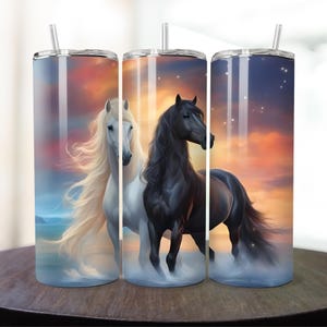 May include: Two stainless steel tumblers with a sunset background and a white horse and a black horse. The tumblers have lids and straws.