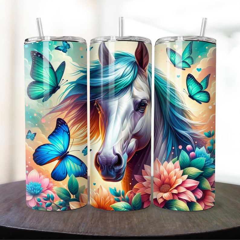 May include: Three stainless steel tumblers with a colorful design featuring a white horse with a blue mane, flowers, and butterflies. The tumblers are a great way to enjoy your favorite beverage.