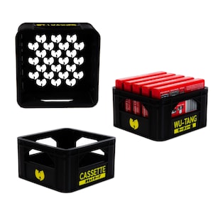 May include: Three black plastic crates with the Wu-Tang Clan logo. The crates are empty and have a yellow label with the words "CASSETTE" and "カセットテープ" on one crate. The other two crates have the words "WU-TANG" and "ウータン" on them.