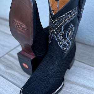 May include: A set of three ceramic mugs with a speckled, matte finish. The mugs are in shades of cream, light gray, and dark gray. Each mug has a simple, minimalist design and a rounded handle.