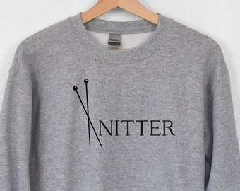 May include: Gray sweatshirt with a black graphic of knitting needles and the word "Knitter" on the front.