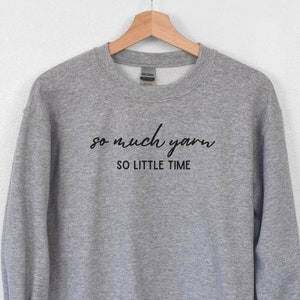 May include: Gray sweatshirt with the text "so much yarn so little time" in black.