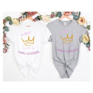 May include: Two t-shirts with a crown graphic and the text "Yarn Goddess". One shirt is white with the text "Knitten? I prefer the term..." and the other shirt is gray.