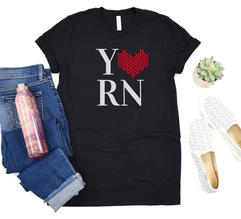 May include: Black t-shirt with a white graphic that says "Y" with a red knitted heart and "RN".