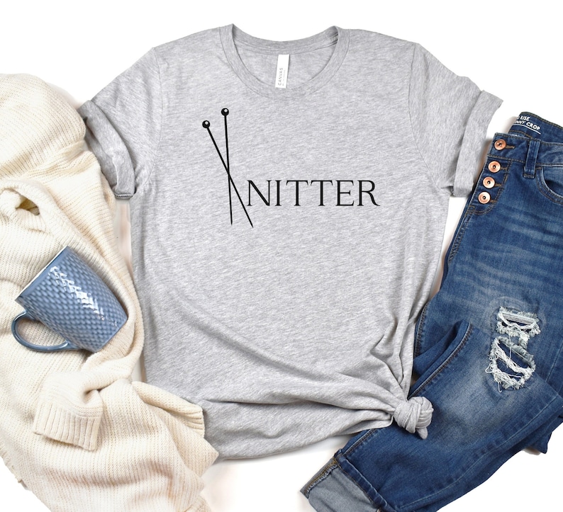 May include: Gray t-shirt with a black graphic of knitting needles and the word "Knitter".