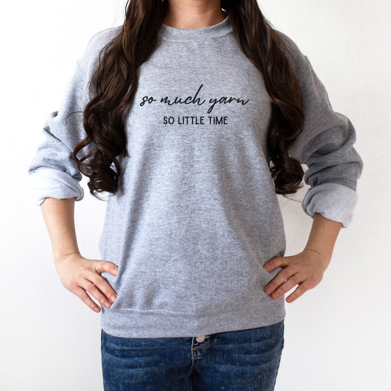 May include: A gray sweatshirt with the text "so much yarn so little time" printed on the front.
