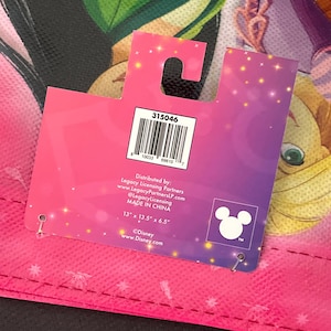 May include: A pink and purple Disney-themed tote bag with a tag. The tag has the number "315046" and the Disney logo. The bag measures 13" x 13.5" x 6.5".