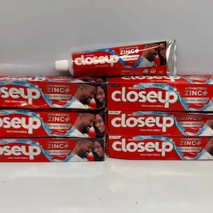 May include: Several red and white "Closeup" toothpaste boxes and a single tube. The boxes and tube display the brand name in white, with "ANTI-BACTERIAL ZINC+" text and a couple's image. The tube is open and ready to use.
