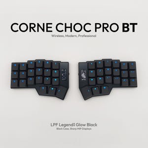 May include: A split black keyboard with blue backlit keys. The keyboard is labeled "CORNE CHOC PRO BT" and "LPF Legend Glow Black". The keys are arranged in a split ergonomic layout. The keyboard is wireless and modern.