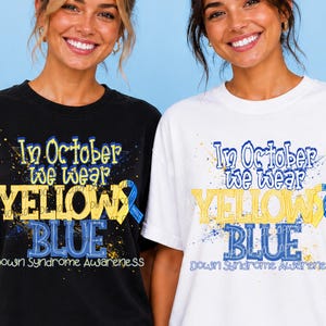 May include: A black t-shirt and a white t-shirt, each featuring a graphic with blue and yellow paint splatter effects and the text: In October we wear YELLOW & BLUE Down Syndrome Awareness, including a yellow and blue awareness ribbon graphic.