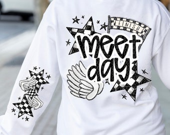 May include: White sweatshirt with a black and white checkered star design and the text "meet day" with a checkered finish line graphic.