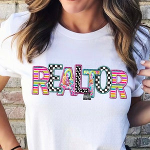 May include: White t-shirt with the word "REALTOR" in colorful patterned letters. The letters are made up of stripes, polka dots, and checkered patterns.