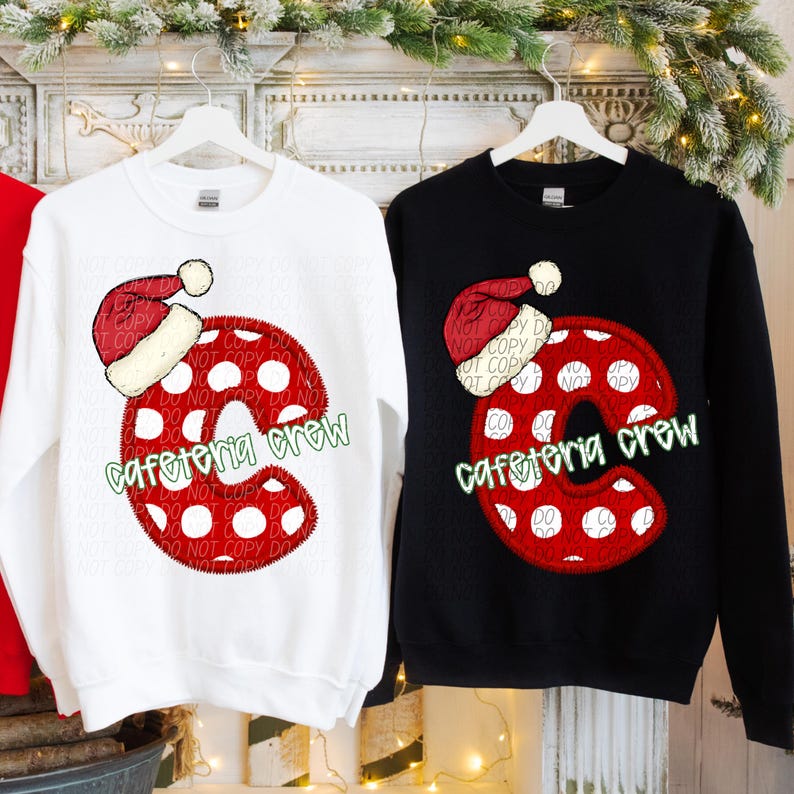 May include: White and black sweatshirts with a Christmas-themed design. Each sweatshirt features a large red letter "C" with white polka dots, a Santa hat, and the words "cafeteria crew" in green.