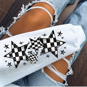 May include: White sweatshirt featuring a black and white checkered star design. The design includes multiple stars of varying sizes, with smaller stars scattered around the main design. The words "DO NOT COPY" are printed on the sweatshirt.