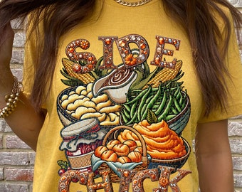 Könnte beinhalten: Senfgelbes T-Shirt mit einem Thanksgiving-Motiv. Die Grafik zeigt die Worte "Side Chick" in kunstvollen Buchstaben, umgeben von Illustrationen von Mais, grünen Bohnen, Kartoffelpüree, Brötchen und Soße.